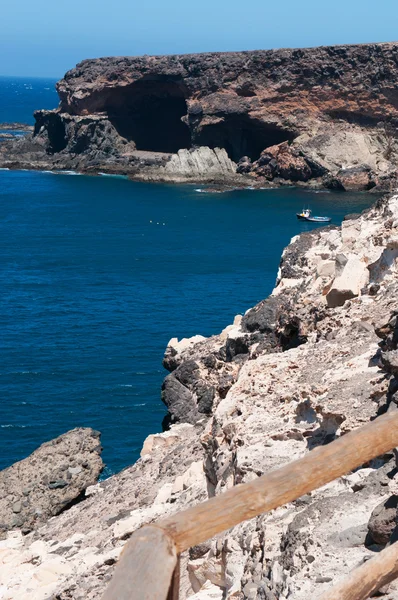 Fuerteventura, Islas Canarias, España: el sendero sobre un acantilado que conduce a las cuevas de Ajuy, el pueblo pesquero en la costa occidental de la isla famosa por sus cuevas, su playa negra y los coloridos barcos — Foto de Stock