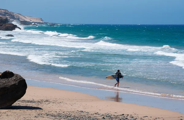 Fuerteventura, Islas Canarias: un surfista en Playa de Garcey, una playa negra, famosa entre los surfistas por sus olas, en la costa occidental de la isla donde se encuentra el naufragio de la nave American Star, naufragada en 1994 — Foto de Stock