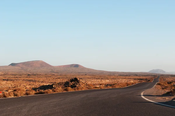 Fuerteventura, Ilhas Canárias, Espanha: vista panorâmica ao pôr-do-sol das montanhas na estrada da pequena aldeia piscatória de Majanicho para a principal cidade de Corralejo — Fotografia de Stock