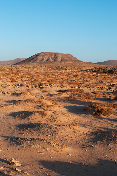 Фуэртевентура, Канарские острова, Испания: вид с воздуха на закат пустынного ландшафта и горы на дороге из маленькой рыбацкой деревушки Маджаничо в главный город Коррехо
