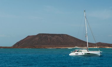Fuerteventura, Kanarya Adaları, İspanya: bir katamaran ve Atlantik Okyanusu'nun berrak su ve panoramik Lobos Adası (Islote de Lobos), küçük bir ada sadece 2 kilometre Fuerteventura Adası kuzeyinde bulunan
