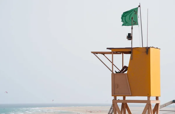 Fuerteventura, Canary Islands, Spain: lifeguard on duty on the watchtower of Playa de Sotavento de Jandia, one of the most famous beaches of Costa Calma (Calm Coast), southeastern coast considered a paradise for surfers — Stock Photo, Image