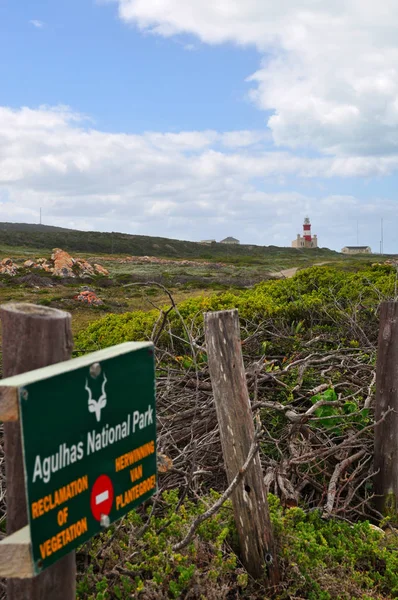 Sudáfrica: vista aérea del faro del Cabo Agulhas, construido en 1849 en el extremo sur del pueblo de L 'Agulhas, y el signo del Parque Nacional Agulhas en el Cabo Agulhas, el extremo sur geográfico del continente africano — Foto de Stock