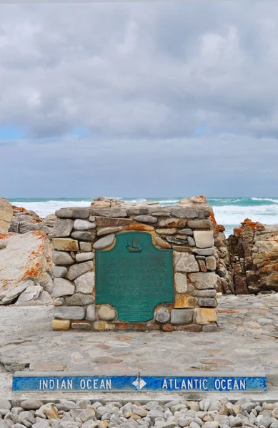 Sudáfrica: vista del marcador que indica la línea divisoria oficial entre los océanos Atlántico e Índico en el Cabo Agulhas, el extremo sur geográfico del continente africano dentro del Parque Nacional Agulhas — Foto de Stock