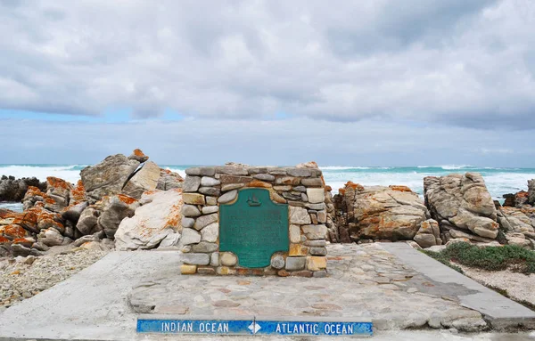 Sudáfrica: vista del marcador que indica la línea divisoria oficial entre los océanos Atlántico e Índico en el Cabo Agulhas, el extremo sur geográfico del continente africano dentro del Parque Nacional Agulhas — Foto de Stock