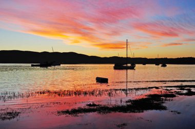Knysna, South Africa: sailboats and a breathtaking sunset at the harbour of Thesen Island, a multi-award winning marina development in the Knysna estuary, town along the famous Garden Route clipart