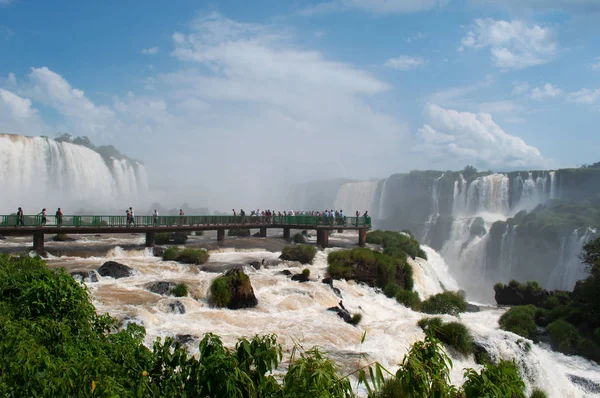 Argentina: people on a walkway at Iguazu Falls, one of the most important tourist attractions of Latin America — Stock Photo, Image