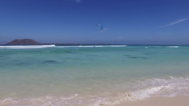 Fuerteventura: Great Playas beach, one of the most famous beaches for surfing and kite surfing, crystal clear water, rock formations, underground, view on the islet of Lobos September 7, 2016 — Stock Video