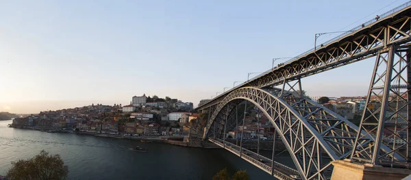 Portugal: boten bij zonsondergang en de skyline van Porto met uitzicht op de Luiz ik brug over de rivier de Douro — Stockfoto