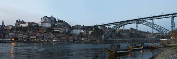 Portugal: boten bij zonsondergang en de skyline van Porto met uitzicht op de Luiz ik brug over de rivier de Douro — Stockfoto