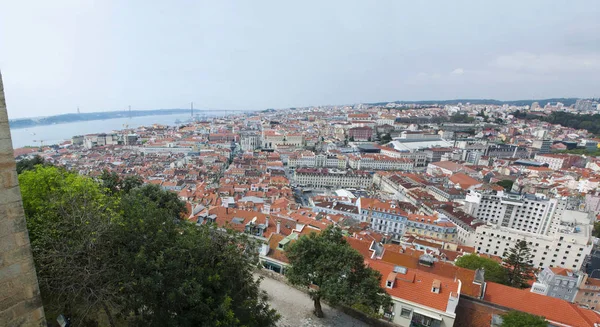 Portugal: o horizonte de Lisboa com vista para os telhados vermelhos, os palácios da Cidade Velha, a Ponte 25 de Abril e o rio Tejo — Fotografia de Stock