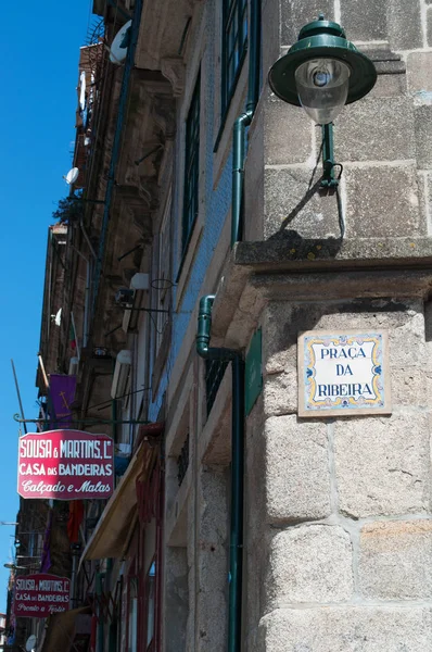 Oporto: una lámpara de calle y el signo de cerámica de la Praca da Ribeira central, la Plaza del Río, con vista a los signos de tiendas de artesanía en el casco antiguo — Foto de Stock