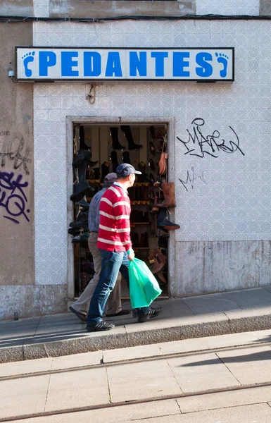 ポルト:靴屋や靴の修理の前で旧市街を歩く人々 — ストック写真