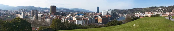 Baskien: skyline i Bilbao och Nervion floden med utsikt över Zubizuri, vita bron eller Campo Volantin bron av Santiago Calatrava, sett från Etxebarria Park — Stockfoto