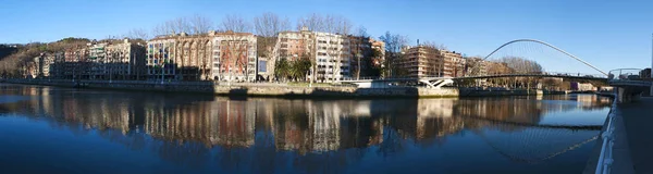 Baskien: skyline i Bilbao och Nervion floden med utsikt över Zubizuri, vita bron eller Campo Volantin bron av Santiago Calatrava — Stockfoto