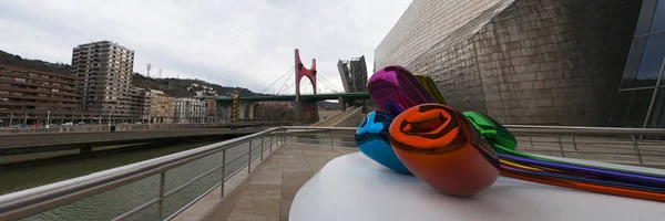 España: los Tulipanes, un ramo de flores multicolores en globo escultura realizada por el artista Jeff Koons y situada en el exterior del Museo Guggenheim Bilbao, con vistas al horizonte — Foto de Stock