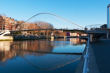 Basque Country, Spain: the skyline of Bilbao and Nervion River with view of the Zubizuri, the white bridge or the Campo Volantin Bridge by Santiago Calatrava clipart
