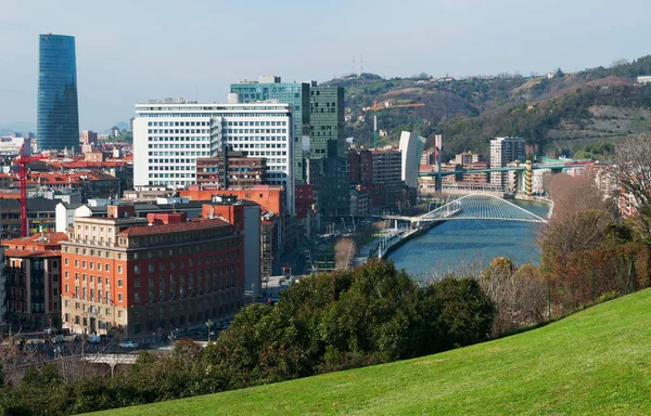 Baskenland, Spanje: de skyline van Bilbao en de Nervion rivier met uitzicht op de Zubizuri, de witte brug of de Campo Volantin brug door Santiago Calatrava, gezien vanuit het Park Etxebarria — Stockfoto