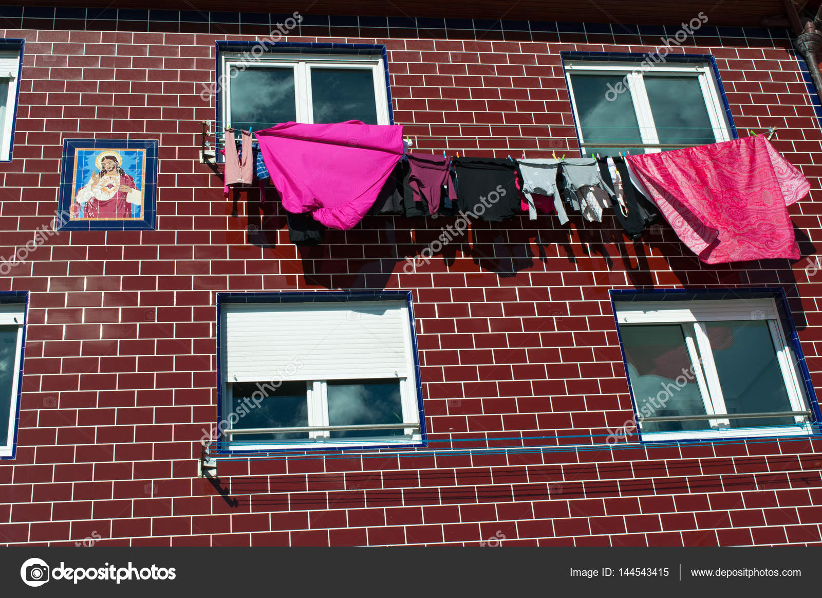 Basque Country Spain Red Building With Votive Ceramic Tiles And Basque Country Spain Red Building With Votive Ceramic Tiles And Windows Laundry Hanging To Dry In The Old City Of Donostia San Sebastian