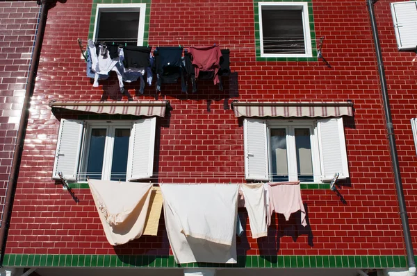 A red building and windows with laundry hanging to dry — Stock Photo, Image