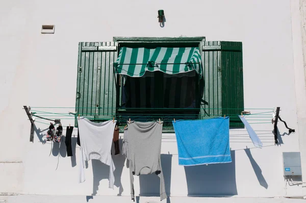 A green window with laundry hanging to dry — Stock Photo, Image