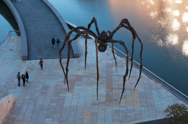 Bilbao, Basque Country, Spain: Maman, the giant spider sculpture made by the artist Louise Bourgeois and located at the exterior of the Guggenheim Museum Bilbao, with view of the reflections on the Nervion River clipart