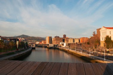 İspanya: Pedro Arrupe yaya köprüsü, Jose Antonio Fernandez Ordonez tarafından tasarlanmış ve modern ahşap yaya köprüsü şafak görülen Bilbao manzarası