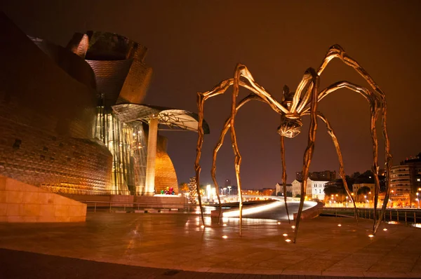 Іспанія, країни Басків: Maman, гігантських павуків скульптура, зроблені художником Луїзи буржуа і розташований на зовнішній вигляд Музей Гугенхайма в Більбао, з видом на горизонт нічного міста — стокове фото