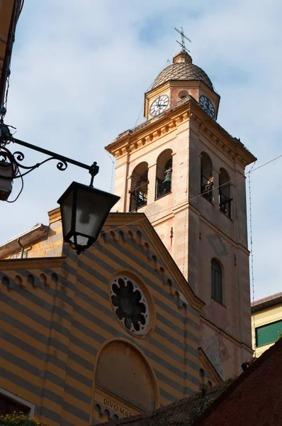 Portofino: een straat lamp en de klokkentoren van het 12e-eeuwse kerk van St. Martin, Divo Martino, de gestreepte kerk gewijd aan Sint-Maarten van Tours in de oudste wijk van de buitenwijk — Stockfoto