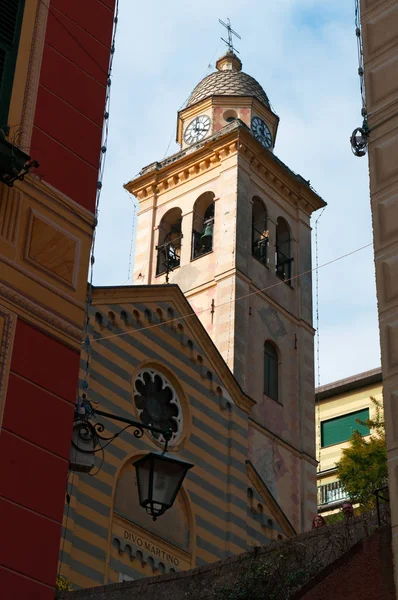 Portofino: een steegje met uitzicht op de klokkentoren van het 12e-eeuwse kerk van St. Martin, Divo Martino, de gestreepte kerk gewijd aan Sint-Maarten van Tours in de oudste wijk van de buitenwijk — Stockfoto