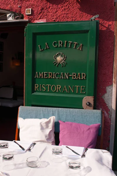 Portofino, Italia: cojines y mesa fuera del bar americano La Gritta, famoso restaurante desde 1954 lugar de encuentro para la jet set internacional y la realeza que atracó en el pueblo de pescadores — Foto de Stock