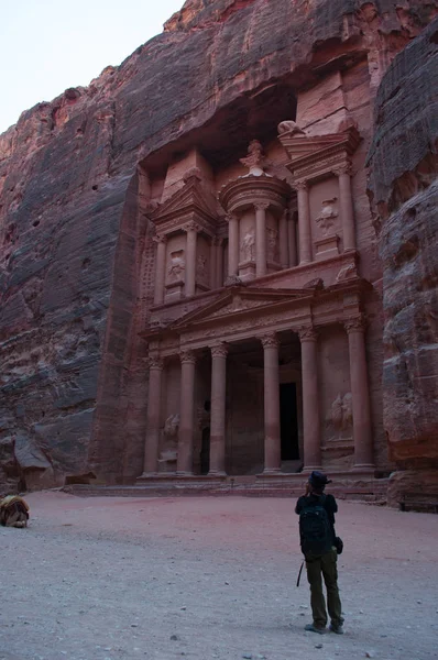 Jordania: un hombre frente a Al-Jazneh, el Tesoro, el templo más famoso de la ciudad arqueológica nabatea de Petra, construido por los nabateos árabes y tallado en una cara de piedra arenisca — Foto de Stock