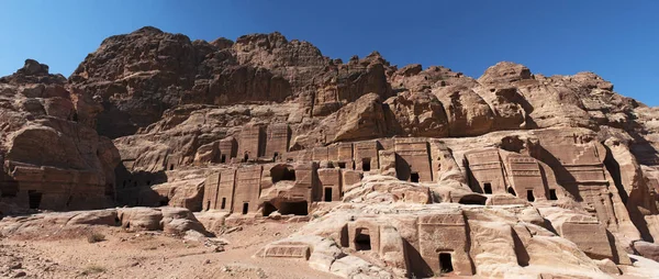 Jordânia: panorâmica da Rua das Fachadas, fileira de túmulos nabateu monumentais esculpidos na face sul do penhasco que fica além do Tesouro na cidade arqueológica de Petra — Fotografia de Stock