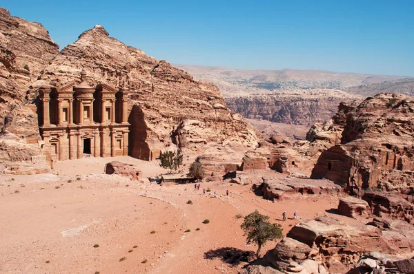 Jordan: det jordanska landskapet med utsikt över klostret, som kallas Ad Deir eller El Deir, den berömda monumental byggnad huggen ur sten i den arkeologiska Nabataean staden Petra — Stockfoto