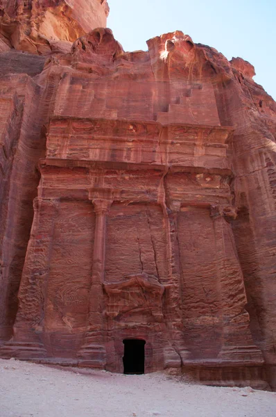 Jordânia: um túmulo vermelho ao longo da rua das fachadas, a linha de túmulos Nabataean monumental carved na cara do penhasco do sul que encontra-se após o Tesouro na cidade Nabataean archaeological de Petra — Fotografia de Stock