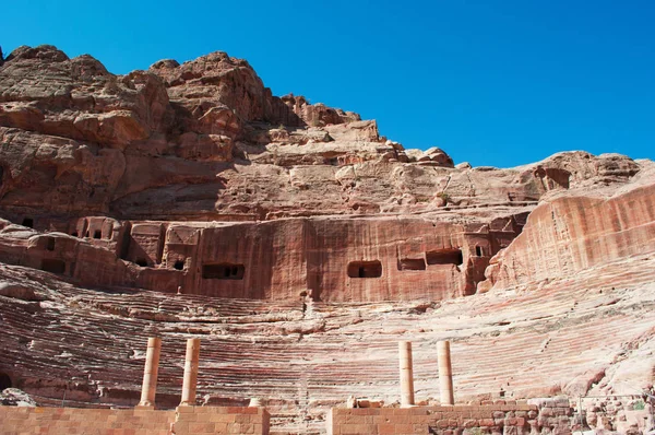 Jordânia: vista do anfiteatro romano, um grande teatro esculpido na rocha com colunas e arquibancadas no final das ruas de fachadas na cidade arqueológica de Petra — Fotografia de Stock