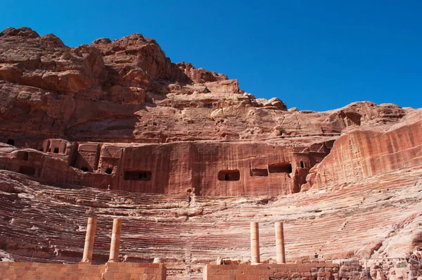 Jordânia: vista do anfiteatro romano, um grande teatro esculpido na rocha com colunas e arquibancadas no final das ruas de fachadas na cidade arqueológica de Petra — Fotografia de Stock