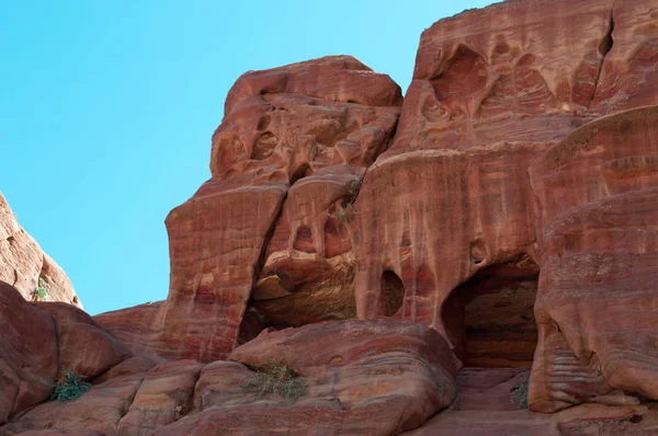 Jordânia: edifícios e diferentes formas, cores e tons das rochas vermelhas vistas andando no cânion no final das ruas de fachadas no vale arqueológico de Nabataean de Petra — Fotografia de Stock