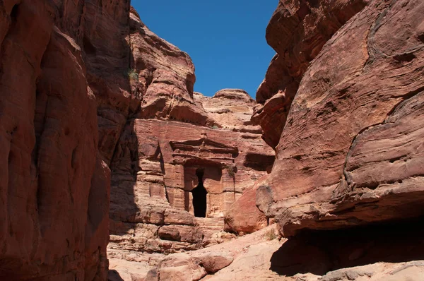 Jordanien, Mellanöstern: vy av en grav utkarvad ur rock av berget på väg upp till klostret i den arkeologiska Nabataean staden Petra — Stockfoto