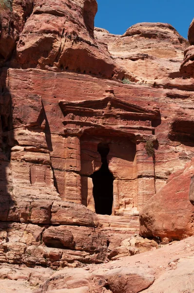 Jordânia, Oriente Médio: vista de um túmulo esculpido na face rochosa da montanha no caminho até o mosteiro na cidade arqueológica de Nabataean Petra — Fotografia de Stock