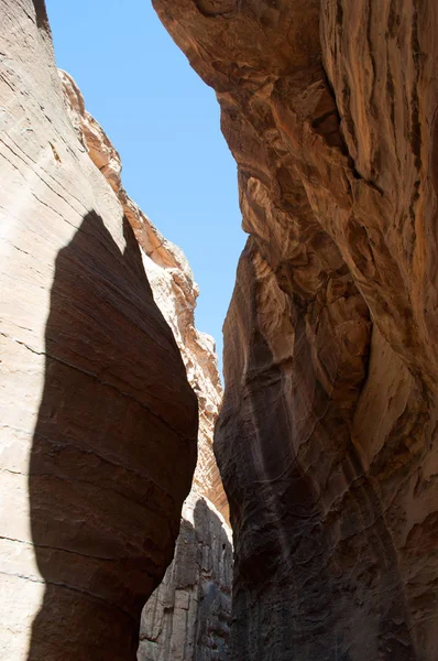 Jordânia, Oriente Médio: diferentes formas, cores e tons das rochas vermelhas vistas andando no cânion do Siq, o Eixo, a entrada principal para a cidade arqueológica de Petra — Fotografia de Stock
