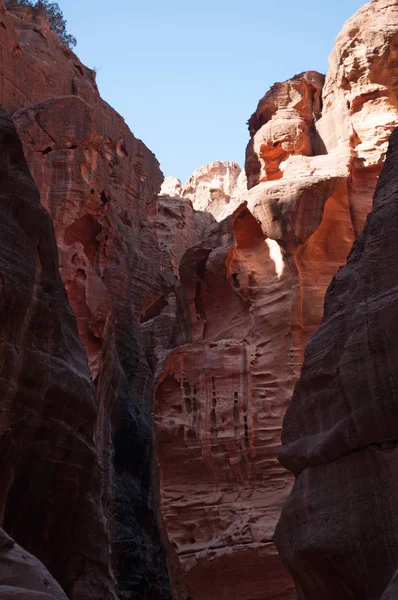 Jordânia, Oriente Médio: diferentes formas, cores e tons das rochas vermelhas vistas andando no cânion do Siq, o Eixo, a entrada principal para a cidade arqueológica de Petra — Fotografia de Stock