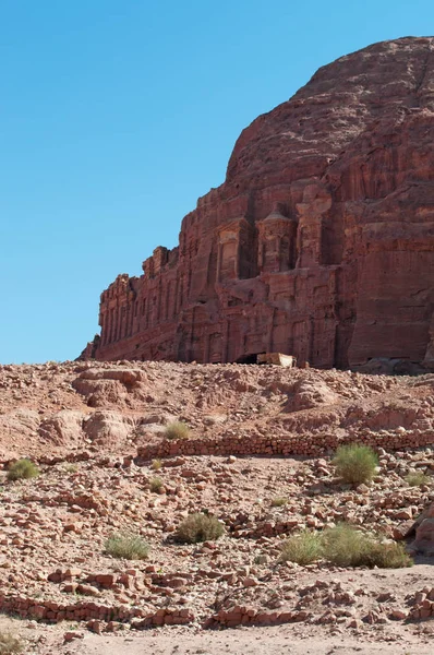 Jordânia, Oriente Médio: vista do Muro dos Reis com os Túmulos Reais, enormes estruturas funerárias esculpidas na face rochosa no sopé da montanha na arqueológica cidade de Petra — Fotografia de Stock