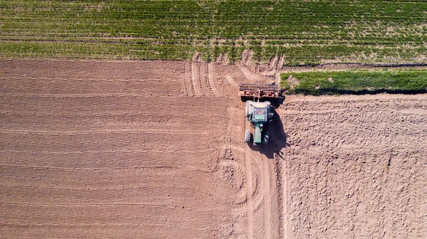 Trator arar os campos, vista aérea de um campo arado e um trator que semeadura — Fotografia de Stock