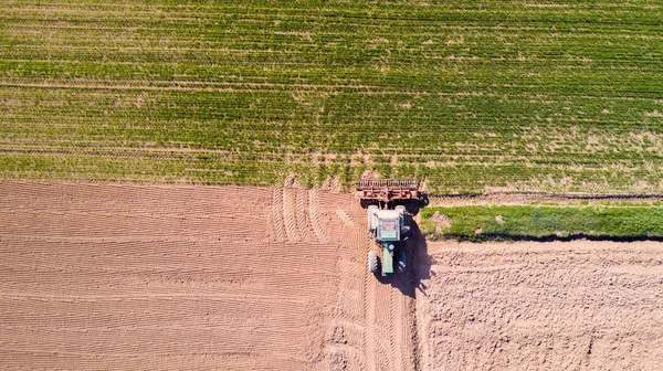 Trator arar os campos, vista aérea de um campo arado e um trator que semeadura — Fotografia de Stock