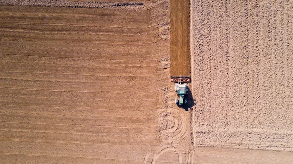 Tractor arando los campos, vista aérea de un campo arado y un tractor que siembra —  Fotos de Stock