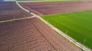 Bir köy yolunda, off-road havadan görünümü bir toprak yol alanlar arasında seyahat bir araba geçiş bir jeep