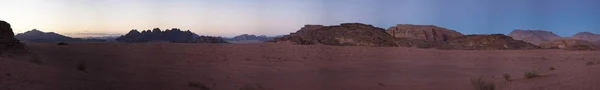 约旦︰ 日落在洛矶山脉在瓦迪鲁姆沙漠，被称为月亮，一个著名的山谷，把切成的砂岩和花岗岩的岩石，看上去就像地球上的火星谷 — 图库照片