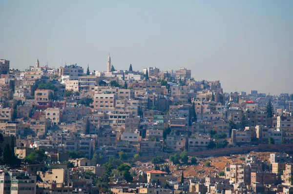 Jordania: vista del horizonte de Ammán, la capital y ciudad más poblada del Reino Hachemita de Jordania, con los edificios, los palacios y las casas vistas a través de la neblina de calor —  Fotos de Stock