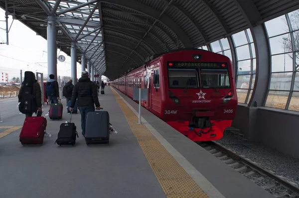 Domodedovo, Rússia: passageiros esperando a partida com o trem vermelho da Aeroexpress, a única ligação ferroviária do aeroporto de Domodedovo para o centro de Moscou — Fotografia de Stock